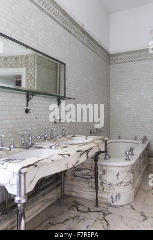 Il bagno in marmo in Mrs Greville'appartamento, Polesden Lacey, Surrey. Progettato nel 1906 da Mewès e Davis, il bagno è simile a quelli che hanno creato per il Ritz Hotel in Londra, con pavimenti in marmo, lavandini e vasca da bagno. Due pozzi sono stati installati con una Foto Stock