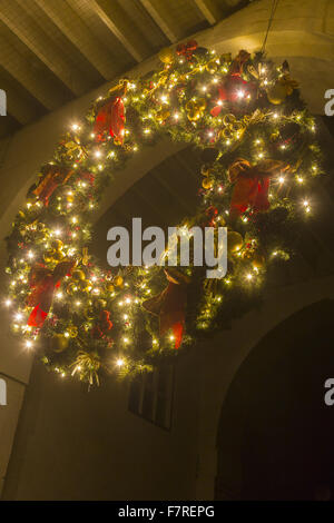 Giant ghirlanda di Natale, incandescente con le luci fairy e pendente da un arco a Polesden Lacey, Surrey. Foto Stock