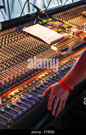 Le manopole e far scorrere i comandi della console di miscelazione / mixer audio in concerto Foto Stock