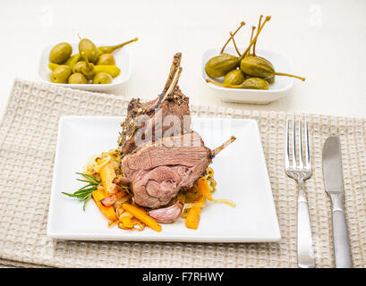 Grigliata di carré di agnello con cipolla carota, aglio e rosmarino Foto Stock