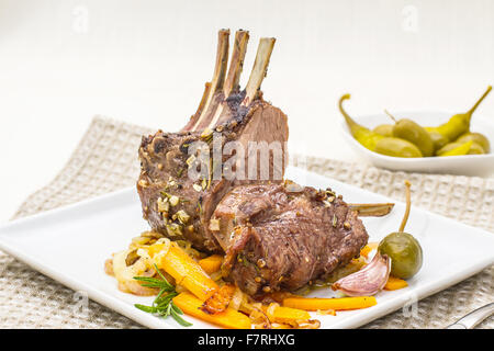 Grigliata di carré di agnello con cipolla carota, aglio e rosmarino Foto Stock