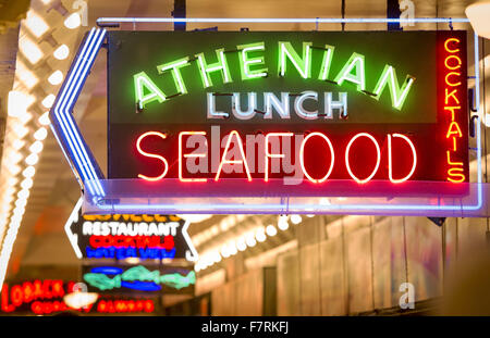 Seattle, Washington, Stati Uniti d'America. 23 Nov, 2015. Seattle è il Mercato di Pike Place ha cominciato in 1907 ed è stato ideato a beneficio dei piccoli agricoltori e pescatori nonché i responsabili di altre merci. Il Mercato di Pike Place situato lungo il fronte mare di Seattle lungo la Baia di Elliott ed è compreso di non lungo il Pike Place, una strada di città, ma anche di diversi piani al di sotto di e. Il Pike Place Market ha subito alcune modifiche nel corso degli anni ma ha mantenuto il suo fascino del vecchio mondo portando i turisti provenienti da tutto il mondo. ------- Nella foto, all'interno di Pike Place Market, insegne al neon con temi di pesce di contrassegnare la specialità alimentari come sho Foto Stock