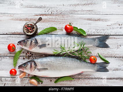 Due materie di spigola con spezie su un vecchio sfondo di legno. Vista superiore Foto Stock