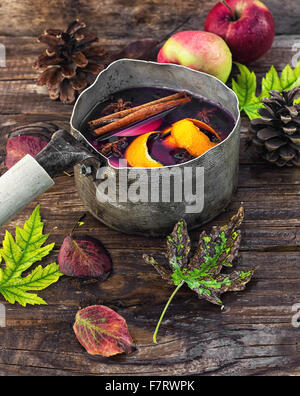 La sangria in stile vecchio cappello bowler sullo sfondo cosparso di foglie di autunno Foto Stock