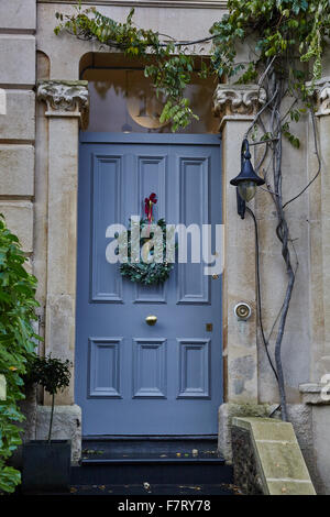 Evergreen Ghirlanda di Natale sul blu della porta anteriore Foto Stock