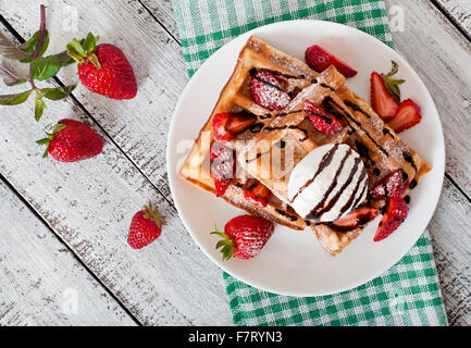 Cialde belghe con fragole e gelati su piastra bianca. Vista superiore Foto Stock