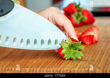 Primo piano immagine di fragole in preparazione per la cottura su un tagliere Foto Stock