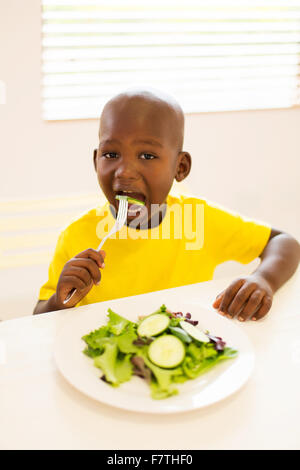 Adorable little boy insalata mangiare a casa Foto Stock