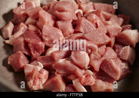 Disossati la carne di maiale cruda in una pentola di stufato Foto Stock