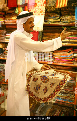 Uomo arabo tappetino di vendita nel Souk Mercato Centrale, Sharjah Emirati Arabi Uniti Foto Stock