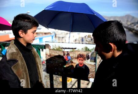 A Kabul, Afghanistan. 3 dicembre, 2015. Afghan ragazzi guardare una foto durante un ambientale mostra fotografica a Kabul, Afghanistan, Dicembre 3, 2015. La mostra si propone di incoraggiare le persone a proteggere l ambiente e di essere grati alla natura. © Omid/Xinhua/Alamy Live News Foto Stock