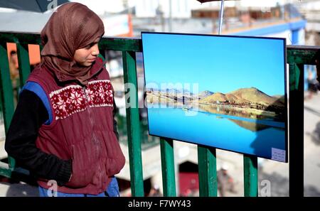 A Kabul, Afghanistan. 3 dicembre, 2015. Una ragazza afghana guarda una foto durante un ambientale mostra fotografica a Kabul, Afghanistan, Dicembre 3, 2015. La mostra si propone di incoraggiare le persone a proteggere l ambiente e di essere grati alla natura. © Omid/Xinhua/Alamy Live News Foto Stock