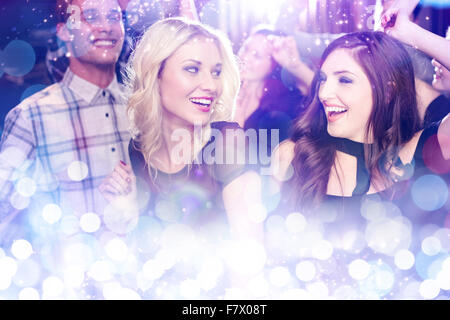 Immagine composita di elegante amici ballare e sorridente Foto Stock