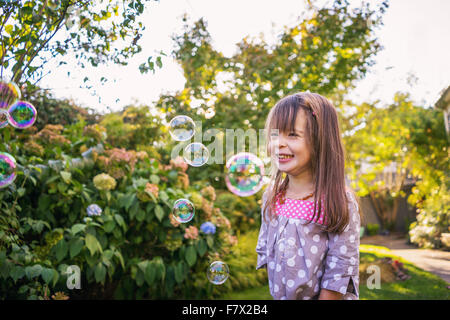 Ragazza sorridente soffiare bolle Foto Stock