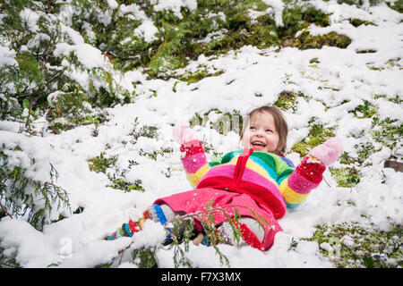 Sorridente ragazza distesa nella neve Foto Stock