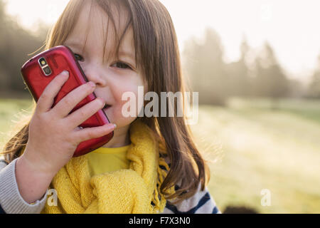 Ragazza sorridente a parlare su un telefono mobile Foto Stock