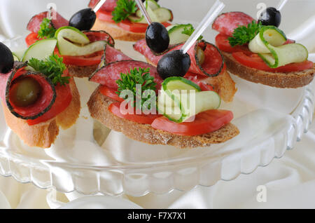 Crostino del baguette con salame su una base di vetro Foto Stock