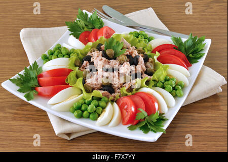 Tonno con olive e capperi e circondato da verdure a dadini Foto Stock