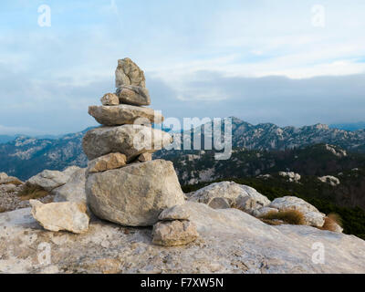 Pila di pietra marchio sul picco di montagna Foto Stock