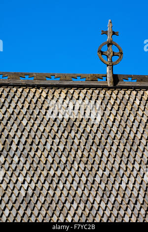 Dragon scala tetto di scandole di legno con la croce sulle antiche Lom doga chiesa in Oppland Norvegia centrale Foto Stock