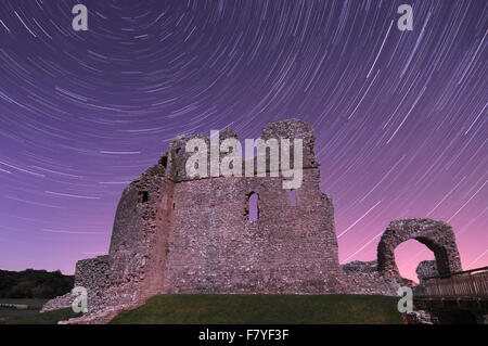 Ogmore Castle nel Vale of Glamorgan di notte con tracce stellari da una lunga esposizione. Foto Stock