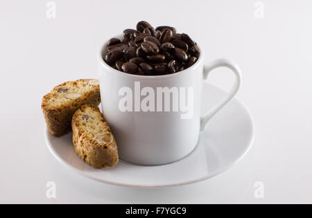 Tazza bianca e i chicchi di caffè e biscotti su sfondo bianco Foto Stock