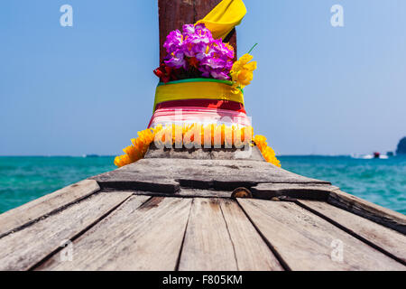 La prua di una tradizionale thai barca dalla coda lunga decorata con nastri e fiori di colore giallo come un fascino di fortuna Foto Stock