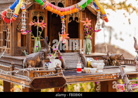 Un piccolo buddista tailandese tempio o santuario con alcune offerte di religiosi Foto Stock