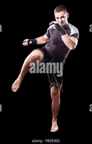 Un giovane kickboxer o boxer isolate su uno sfondo nero Foto Stock