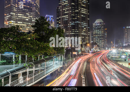 Il traffico di notte a Giacarta, lungo Indonesia città capitale viale principale rivestita con banche , hotel di lusso e centri commerciali per lo shopping Foto Stock