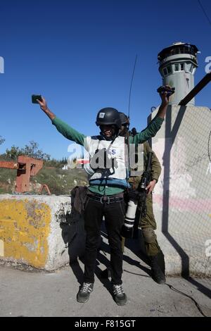 Hebron, West Bank, Territorio palestinese. 4° dic, 2015. Un membro delle forze di sicurezza israeliane ispeziona un giornalista palestinese durante gli scontri nel villaggio di Beit Ummar, vicino alla città di Hebron israeliani Cisgiordania occupata a Dic. 04, 2015 Credit: Wisam Hashlamoun APA/images/ZUMA filo/Alamy Live News Foto Stock