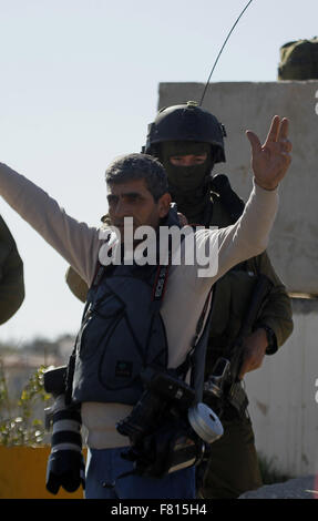 Hebron, West Bank, Territorio palestinese. 4° dic, 2015. Un membro delle forze di sicurezza israeliane ispeziona un giornalista palestinese durante gli scontri nel villaggio di Beit Ummar, vicino alla città di Hebron israeliani Cisgiordania occupata a Dic. 04, 2015 Credit: Wisam Hashlamoun APA/images/ZUMA filo/Alamy Live News Foto Stock