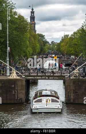 Barca sotto il ponte su un canale ad Amsterdam Foto Stock