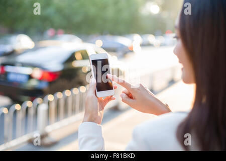 Giovane donna utilizzando smart phone Foto Stock