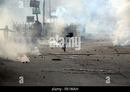 Il Kashmir. 4 dicembre, 2015. Un musulmano del Kashmir protester schivato durante il pro-libertà dimostrazioni nel vecchio Srinagar la capitale estiva della controllata indiana del Kashmir. I manifestanti arrabbiati ha preso la strada principale della zona Nowhatta di vecchi Srinagar e gridò anti India slogan subito dopo il Venerdì di Congregazione la preghiera si è conclusa a Srinagar la Grande Moschea. La polizia ha poi licenziato strappare fumogeni agglomerati in forma di pellets, rivestiti di gomma per i proiettili e granate stun per disperdere pro libertà contestatori. Credito: PACIFIC PRESS/Alamy Live News Foto Stock