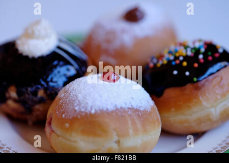 Elegantemente tradizionale Sufganiyot fritte ciambella rotonda mangiato durante la festa ebraica di Hanukkah, la festa delle luci Foto Stock