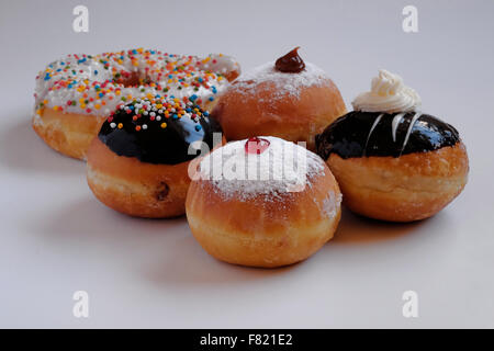 Elegantemente tradizionale Sufganiyot fritte ciambella rotonda mangiato durante la festa ebraica di Hanukkah, la festa delle luci Foto Stock