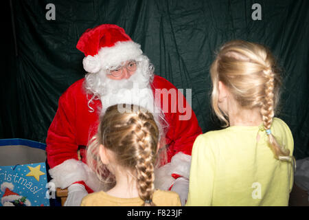 Due ragazze giovani parlare con Babbo Natale a Santa Grotta Foto Stock