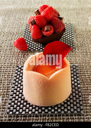 Artigiano Patissier bianco torta al cioccolato con una spugna caso e fragola il riempimento, coperto con rosa bianco cioccolato in polvere Foto Stock