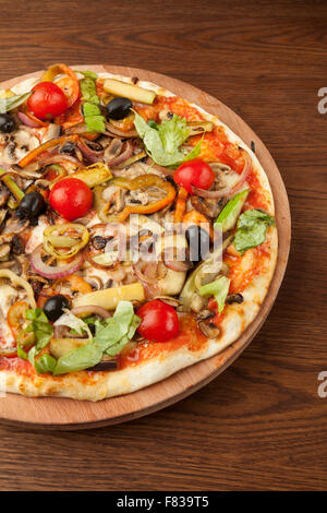 Pizza vegetariana con le verdure sul piatto di legno Foto Stock