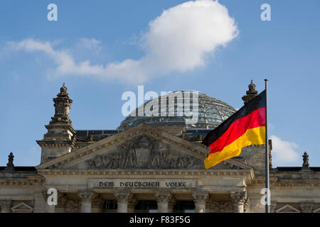 La bandiera tedesca battenti di fronte al Reichstag di Berlino, Germania. Il Parlamento tedesco con cupola di vetro di Norman Foster Foto Stock