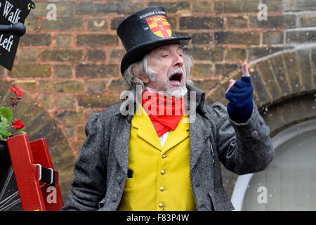 Rochester, Kent, 5 dicembre. Il primo giorno del weekend di Dickensian annuale festa di Natale - Keith Beckford, alias "William Tompkins, Lamplighter' si arrampica la sua scala per cantare la folla Foto Stock