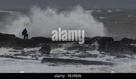 Porthcawl, Wales, Regno Unito, 5 dicembre 2015. Un fotografo si mette in pericolo per catturare le onde enormi battendo il Galles del Sud Costa. Credito: Tom Guy/Alamy Live News Foto Stock
