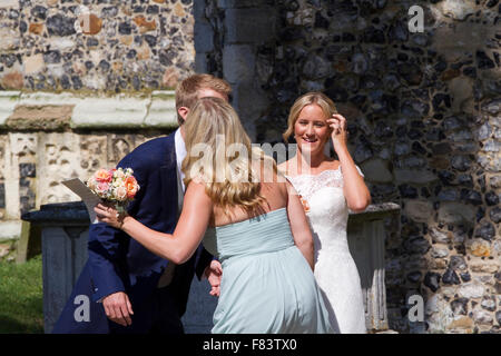 Damigella baci appena sposato sposo mentre la sposa sorrisi Foto Stock