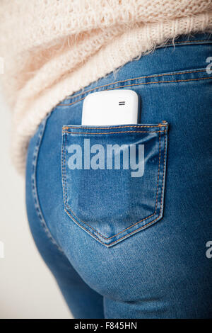 Telefono cellulare nella tasca posteriore di un womans jeans. Foto Stock