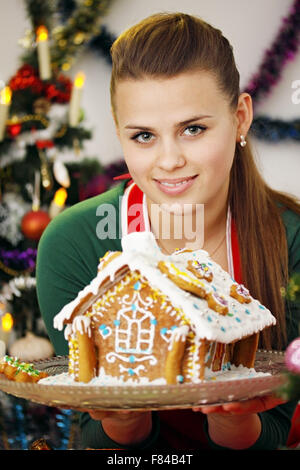 Donna e gingerbread house Foto Stock