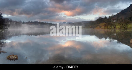 Tramonto nel Langdales guardando attraverso Loughrigg Tarn in inverni freddi sera Foto Stock