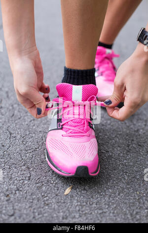 Giovane donna lacci delle scarpe di legatura Foto Stock