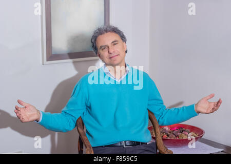 Uomo di mezza età apre le braccia sventolare mentre è seduto Foto Stock