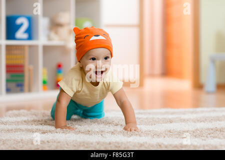 Gattona kid o bambino a casa su un tappeto Foto Stock